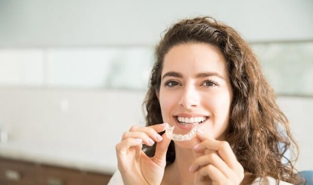 Temukan Alat untuk Meratakan Gigi dengan Nyaman dan Efektif! 1 seorang perempuan sedang menunjukkan cara menggunakan aligner gigi
