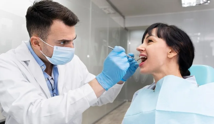 Kapan Waktu Terbaik Periksa Gigi Setelah Lebaran? 5 seorang dokter sedang periksa gigi seorang pasien perempuan yang menggunakan baju putih