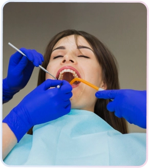 Pasien wanita sedang menerima perawatan gigi profesional dengan alat dental untuk mendapatkan senyum lebih berani