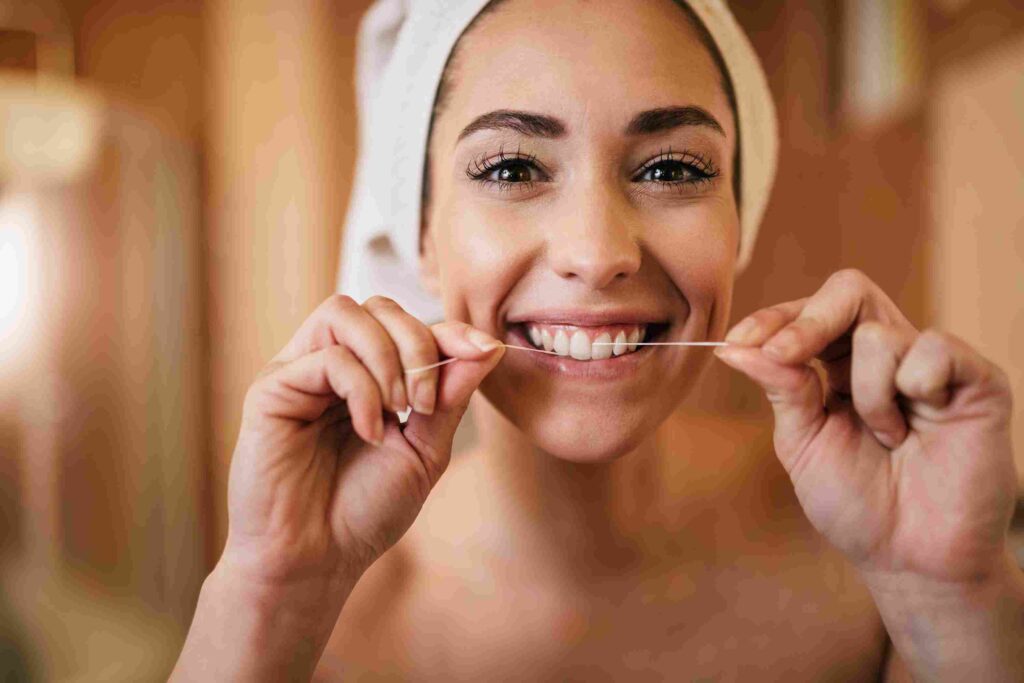 Apa itu Flossing Gigi? Berikut Rahasia Kesehatan Gigi dan Mulut 1 beautiful woman using dental floss cleaning her teeth bathroom 11zon drg Ardianti