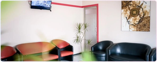 Service Behel 11 Area ruang tunggu yang nyaman dan bersih di Klinik Drg. Adianti dengan sofa, TV, dan dekorasi dinding.