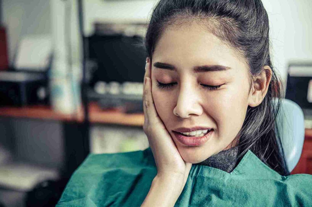 Mengenal Gigi Karies dari Penyebab, Gejala Hingga Pencegahannya 1 wanita memegang pipi karena sakit gigi karies